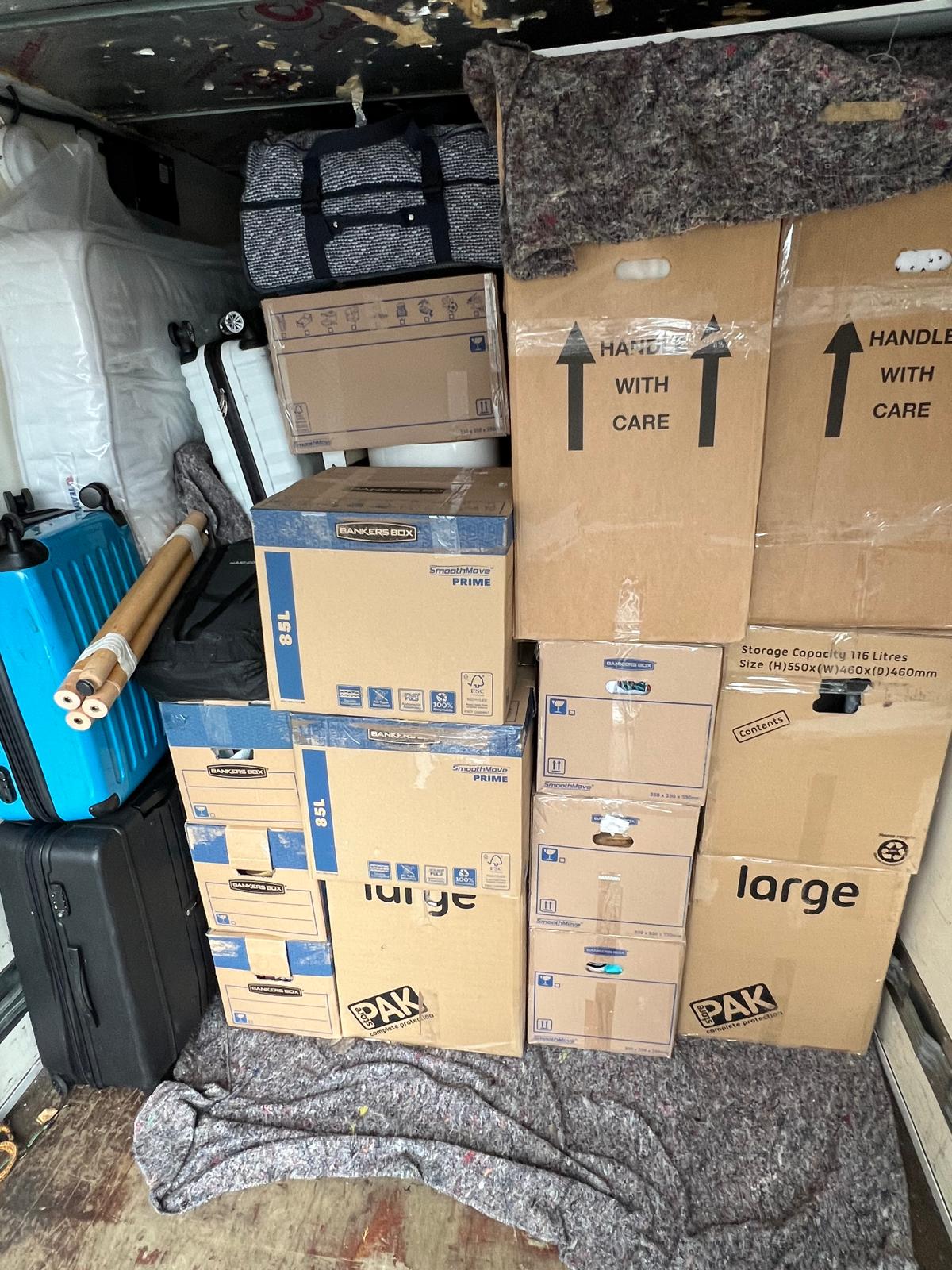 Stacked furniture and boxes inside a Luton-sized van.